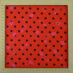 Red jersey fabric with small black polka dots and pink safety pins