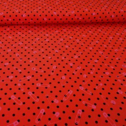 Red jersey fabric with small black polka dots and pink safety pins